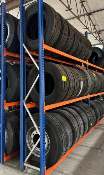 Stalowe regały magazynowe wypełnione oponami do samochodów ciężarowych.